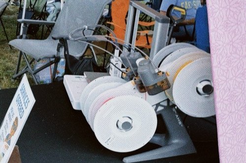 A Bambu Lab printer with four filament spools, printing